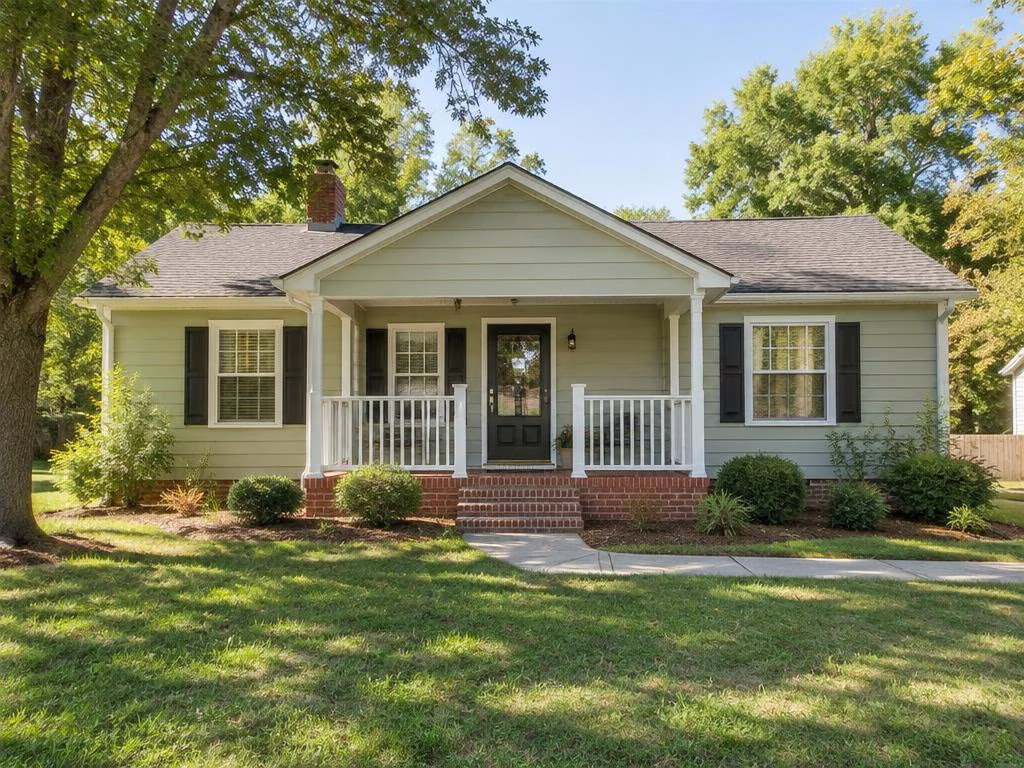 An inviting single-story home with a front porch and mature trees